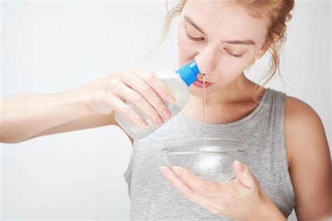 Žena si robí výplach nosa pomocou špeciálnej nádobky