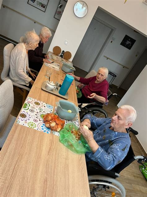Opatrovateľka pomáhajúca seniorovi s domácimi prácami