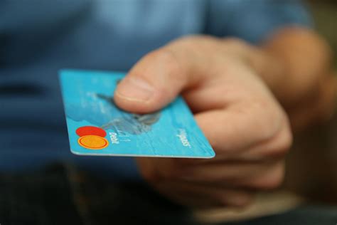 Platobná karta v ruke staršieho človeka pri bankomate