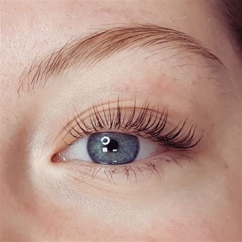 Žena si prečesáva mihalnice po lash lifte