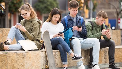 Mladí ľudia používajúci sociálne siete na smartfónoch