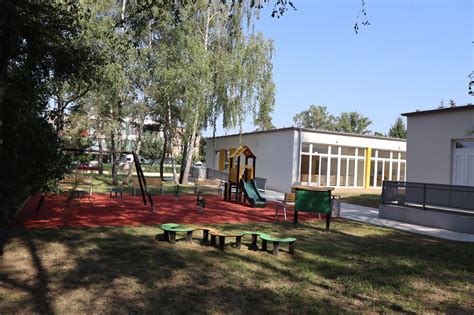 Rodičia a personál jaslí diskutujúci o pokroku dieťaťa