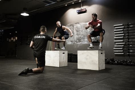 Skupinka cvičiacich začiatočníkov vo fitness centre pod dohľadom trénera