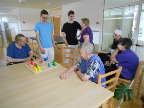 Skupina seniorov hrajúcich stolové hry a spoločne sa smejúcich