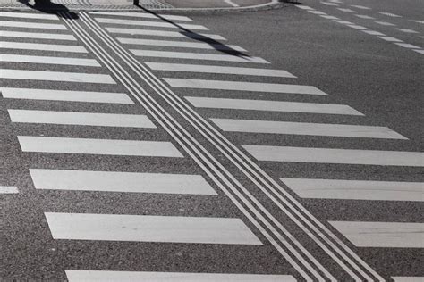 Osoba s bielou paličkou prechádzajúca cez priechod pre chodcov