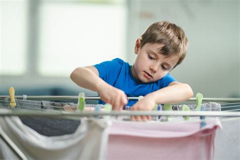 Dievča pomáha s domácimi prácami, zatiaľ čo iné sa hrá