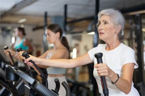 Seniorka cvičí v skupine s inštruktorom