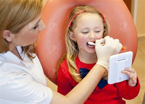 Dentálna hygienička vysvetľujúca správnu techniku čistenia zubov