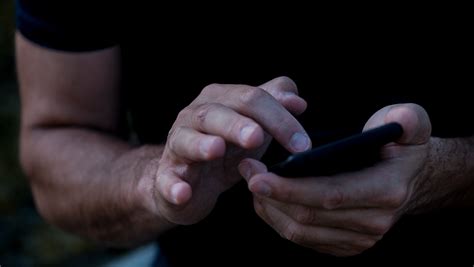 Starší človek používa vyklápací mobilný telefón