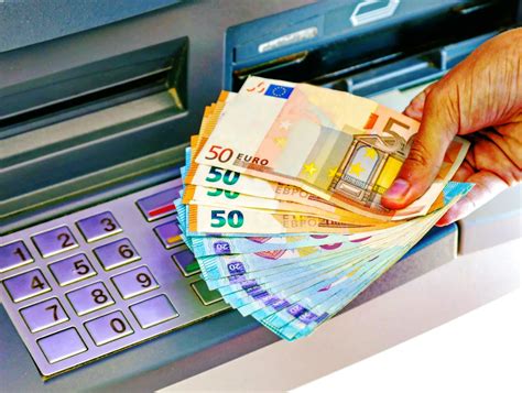 Senior pri bankomate vyberá peniaze