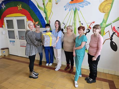 Interiér denného centra s ľuďmi venujúcimi sa rôznym aktivitám