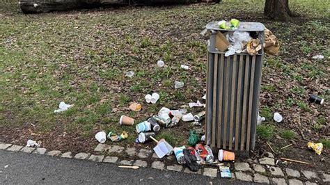 Seniori zbierajú odpadky v parku s vrecami na recykláciu