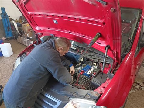 Automechanik vykonávajúci kontrolu motora vozidla