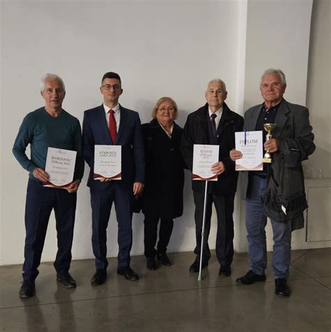 Skupina usmievajúcich sa seniorov študujúcich v učebni