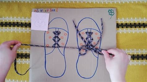 Dieťa trénuje viazanie šnúrok na kartónovom modeli topánky