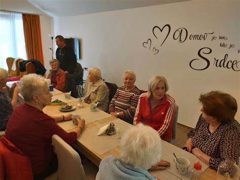 Ilustrácia domova dôchodcov s usmievavými seniormi a personálom