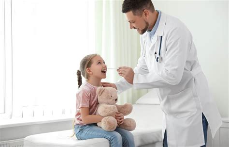 Lekárka vyšetrujúca dieťa v pediatrickej ambulancii