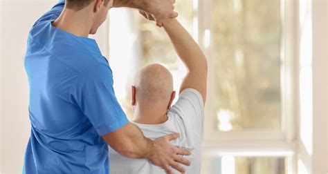 Fyzioterapeut cvičí s imobilným pacientom v rámci rehabilitácie.