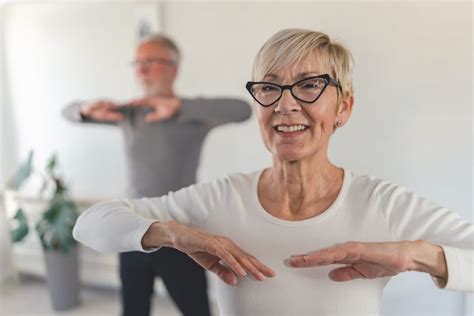 Seniori s obmedzenou pohyblivosťou vykonávajúci ľahké cvičenia s fyzioterapeutom