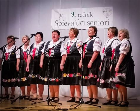 Seniori na kultúrnom podujatí, spievajúci a tancujúci