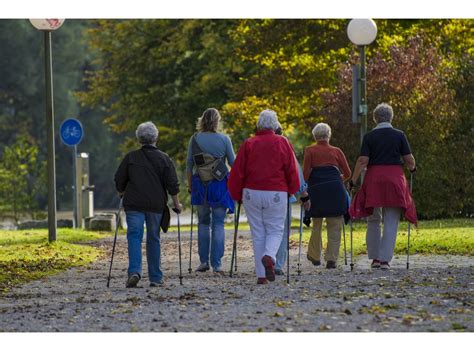 Skupina seniorov na prechádzke s palicami Nordic Walking v prírode