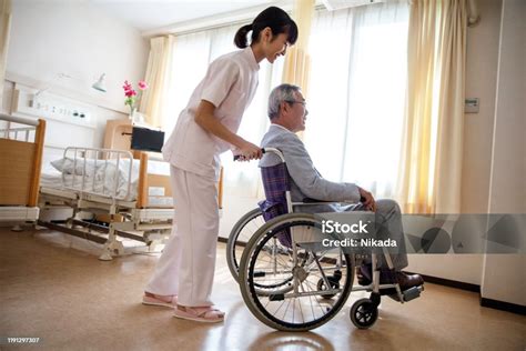 Senior na vozíku cvičiaci s drevenou tyčou