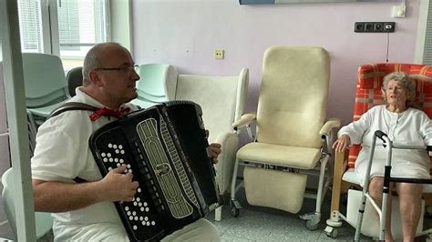 Seniori na spoločnom speve s harmonikou
