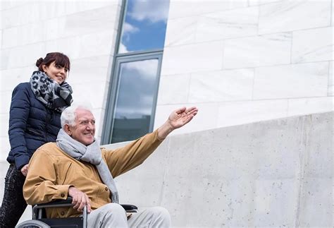 Staršia žena opatruje staršieho muža s invalidným vozíkom
