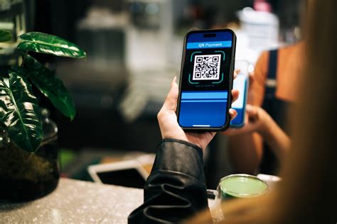 Ilustrácia: Podnikateľ pri pokladnici s QR kódom na displeji pre bezhotovostnú platbu