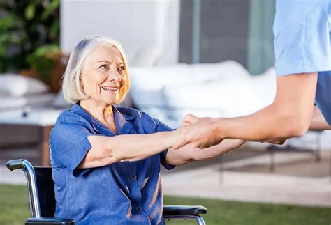 Opatrovateľka pomáhajúca seniorovi s fyzioterapiou