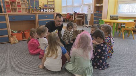 Senior čítajúci knihu deťom v škôlke